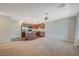 Bright living room with neutral carpeting, stainless steel appliances, and a view into the kitchen area at 757 Omaggio Pl, Henderson, NV 89011