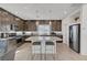 Gourmet kitchen featuring dark wood cabinetry, stainless steel appliances, a large center island with seating at 7953 Mountain Lilac St, Las Vegas, NV 89113