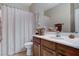 This well-lit bathroom offers a vanity with wood cabinets and a shower with a curtain at 8113 Bay Colony St, Las Vegas, NV 89131