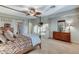 Well-lit bedroom boasts a four-poster bed, plush carpet, dresser, and natural light from the window at 8113 Bay Colony St, Las Vegas, NV 89131