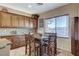Cozy dining area with wooden cabinets, a decorative backsplash, a window, and seating for four at the table at 8113 Bay Colony St, Las Vegas, NV 89131
