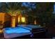 Illuminated backyard hot tub with a cover, surrounded by desert landscaping for a private spa experience at 8113 Bay Colony St, Las Vegas, NV 89131