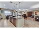 Spacious kitchen and living room with tile flooring, kitchen island, stainless steel appliances, and ample lighting at 8113 Bay Colony St, Las Vegas, NV 89131