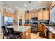 Well-lit kitchen featuring a granite island, stainless steel appliances, and wood cabinetry at 8698 Waterford Bend St, Las Vegas, NV 89123