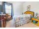 Bright bedroom featuring a bed with a patterned quilt, wicker furniture, and sheer curtains at 928 Collingtree St, Las Vegas, NV 89145