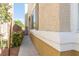 Side view of a home with tan stucco, trimmed windows and a walkway alongside the property at 928 Collingtree St, Las Vegas, NV 89145