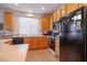 Well-lit kitchen with light oak cabinets, a black gas range, and ample counter space at 928 Collingtree St, Las Vegas, NV 89145