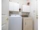 Convenient laundry room with washer, dryer, white cabinets for storage, and gold door knobs at 928 Collingtree St, Las Vegas, NV 89145
