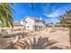 View of the home's exterior featuring a tile roof, palm trees, and a spacious backyard at 1009 Nawkee Dr, North Las Vegas, NV 89031