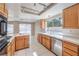 Bright kitchen with wooden cabinets, tile countertops, and stainless steel appliances at 1009 Nawkee Dr, North Las Vegas, NV 89031