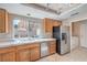 Traditional-style kitchen featuring wood cabinets, stainless steel appliances, and a large window overlooking the backyard at 1009 Nawkee Dr, North Las Vegas, NV 89031