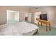 Large bedroom with view to an attached room and bathroom, TV on a table, and a large bed at 1009 Nawkee Dr, North Las Vegas, NV 89031