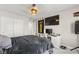 Bedroom with a large window, wood-look ceiling fan, tv and gray walls at 10101 Heron Lake Ave, Las Vegas, NV 89178