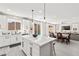 Bright kitchen with white cabinetry, island with seating, and open layout to the dining and living areas with pool view at 10101 Heron Lake Ave, Las Vegas, NV 89178