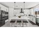 Modern kitchen features white cabinets, a large center island with seating, stainless steel appliances, and pendant lighting at 10101 Heron Lake Ave, Las Vegas, NV 89178
