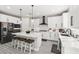 Well-equipped kitchen with white cabinets, black hardware, an island with seating, and stainless steel appliances at 10101 Heron Lake Ave, Las Vegas, NV 89178