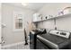 Bright laundry room featuring modern washer and dryer units with shelves for storage at 10101 Heron Lake Ave, Las Vegas, NV 89178