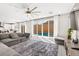 Spacious living room with large windows, a comfortable sectional sofa, and a view of the pool at 10101 Heron Lake Ave, Las Vegas, NV 89178