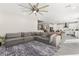 Open living space with a sectional sofa, dining area, and kitchen featuring white cabinets and modern appliances at 10101 Heron Lake Ave, Las Vegas, NV 89178