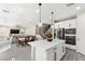 Open concept: kitchen with island seating flows into dining and living areas with modern finishes and natural light at 10101 Heron Lake Ave, Las Vegas, NV 89178