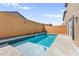In-ground pool with Baja shelf, surrounded by a brick privacy wall and concrete patio at 10101 Heron Lake Ave, Las Vegas, NV 89178