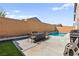 In-ground pool with Baja shelf, surrounded by brick privacy wall and patio furniture set at 10101 Heron Lake Ave, Las Vegas, NV 89178