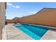 In-ground pool with Baja shelf, surrounded by brick privacy wall and patio furniture set at 10101 Heron Lake Ave, Las Vegas, NV 89178