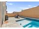 In-ground pool with Baja shelf, surrounded by brick privacy wall and patio furniture set at 10101 Heron Lake Ave, Las Vegas, NV 89178