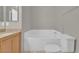 Bright bathroom features a tub, toilet, and a light wood vanity at 10550 W Alexander Rd # 2064, Las Vegas, NV 89129
