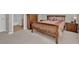 Cozy bedroom with neutral carpet and wooden furnishings, complemented by a light-filled bathroom in the background at 10550 W Alexander Rd # 2064, Las Vegas, NV 89129