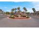 Gated community entrance with palm trees and desert landscaping in a roundabout providing secure and attractive access at 10550 W Alexander Rd # 2064, Las Vegas, NV 89129
