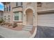 Inviting stucco home features an arched entryway, tidy landscaping, and an attached garage at 10550 W Alexander Rd # 2064, Las Vegas, NV 89129