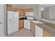 Traditional kitchen with white appliances, tile floor, and light wood cabinets at 10550 W Alexander Rd # 2064, Las Vegas, NV 89129