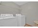 Practical laundry room boasts a washer, dryer, and wire shelving for convenient storage at 10550 W Alexander Rd # 2064, Las Vegas, NV 89129