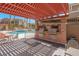 Community outdoor kitchen with built in grill and seating, and a glimpse of the pool at 10550 W Alexander Rd # 2064, Las Vegas, NV 89129