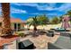 Beautifully landscaped backyard with brick pavers, lounge chairs, and mature palm trees, ideal for relaxation at 1110 Azure Heights Pl, Las Vegas, NV 89110