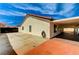 Backyard features a stucco house with a red tiled roof and large concrete driveway and patio at 1110 Azure Heights Pl, Las Vegas, NV 89110