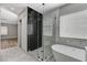 Beautiful bathroom featuring a bathtub, glass-enclosed shower with black tile, and white marble patterned tile at 1110 Azure Heights Pl, Las Vegas, NV 89110