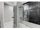 Modern bathroom with a black tiled shower with glass door and shower head, and white tiled walls at 1110 Azure Heights Pl, Las Vegas, NV 89110