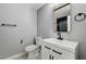 Elegant bathroom featuring a white vanity with matte black fixtures, a black-framed mirror, and tiled floors at 1110 Azure Heights Pl, Las Vegas, NV 89110