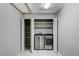 Bright laundry area featuring modern side-by-side washer and dryer units, storage shelves and white tiled floor at 1110 Azure Heights Pl, Las Vegas, NV 89110