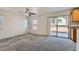 Cozy living room features plush carpeting, large windows, and a sliding glass door for natural light and outdoor access at 1129 Paradise Vista Dr, Henderson, NV 89002