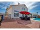 Backyard features outdoor seating under a large umbrella, a built-in grill, and a sparkling pool at 1142 Teal Point Dr, Henderson, NV 89074