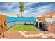 This backyard features a custom fence, artificial grass, a grilling area, and a bicycle at 1142 Teal Point Dr, Henderson, NV 89074