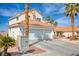 Charming two-story home with a three-car garage and terra cotta roof, framed by lush palm trees and desert landscaping at 1142 Teal Point Dr, Henderson, NV 89074