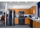 Functional kitchen with black appliances, wooden cabinets, and tiled flooring at 1142 Teal Point Dr, Henderson, NV 89074