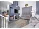 Cozy living room with fireplace, grey sofas, tall ceilings, and a large blue accent wall at 1142 Teal Point Dr, Henderson, NV 89074