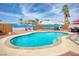 Relax by this backyard pool surrounded by palm trees, outdoor seating, and a grilling area at 1142 Teal Point Dr, Henderson, NV 89074