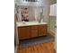 Bathroom featuring double sinks, wood floors, tile floors, and a shower stall for convenience at 1286 N Sloan Ln, Las Vegas, NV 89110
