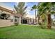Large backyard with lush greenery, manicured lawn, and multiple relaxation areas at 129 Chateau Whistler Ct, Las Vegas, NV 89148